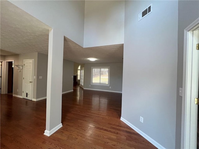 interior space featuring dark wood-style floors, visible vents, and baseboards