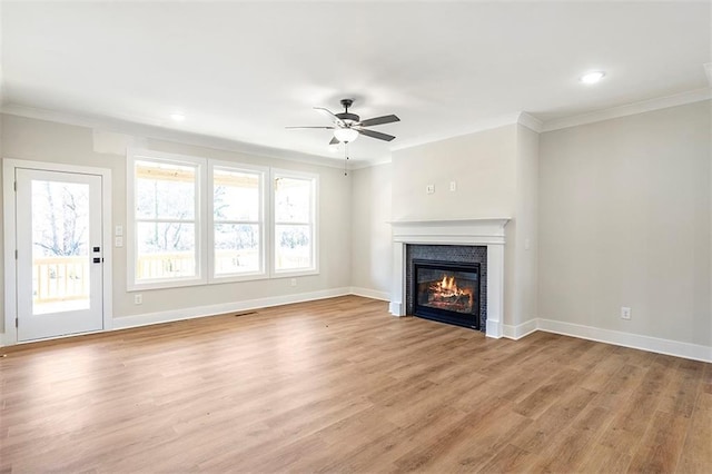 unfurnished living room with ceiling fan, a healthy amount of sunlight, light wood-type flooring, and ornamental molding