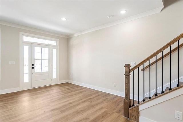 foyer featuring light wood-type flooring and ornamental molding