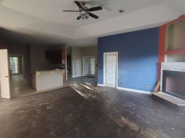 164 Mcclain Cir, Macon, GA 31216 - unfurnished living room with a ceiling fan, a fireplace with raised hearth, and a raised ceiling