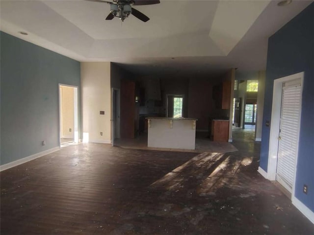 164 Mcclain Cir, Macon, GA 31216 - unfurnished living room with a raised ceiling, ceiling fan, and wood finished floors