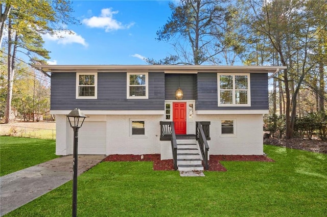 bi-level home with a garage and a front lawn