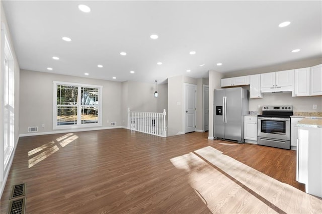 kitchen featuring stainless steel appliances, white cabinetry, and dark wood-type flooring