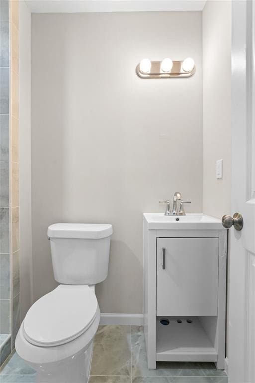 bathroom with tile patterned flooring, vanity, and toilet