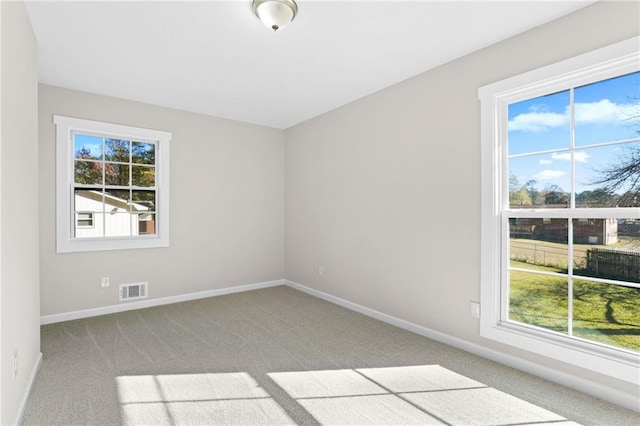 unfurnished room with light colored carpet and a wealth of natural light