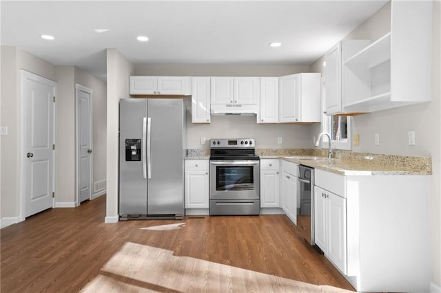 kitchen with stainless steel appliances, white cabinetry, light hardwood / wood-style floors, and sink