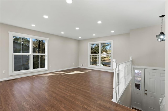 unfurnished living room with dark hardwood / wood-style floors and a wealth of natural light