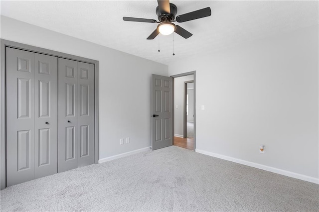 unfurnished bedroom featuring ceiling fan, a closet, carpet, and baseboards