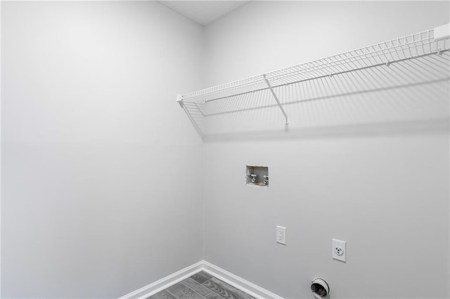 clothes washing area with laundry area, baseboards, dark wood-type flooring, washer hookup, and electric dryer hookup