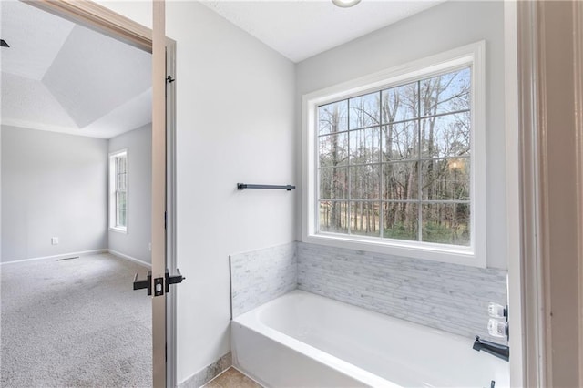 full bath with baseboards and a bath