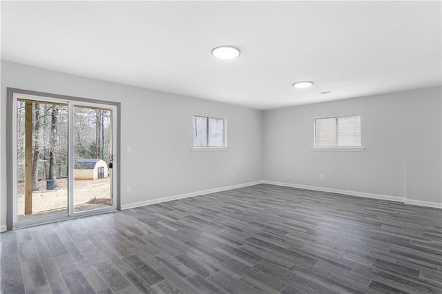 unfurnished room with dark wood-style flooring and baseboards