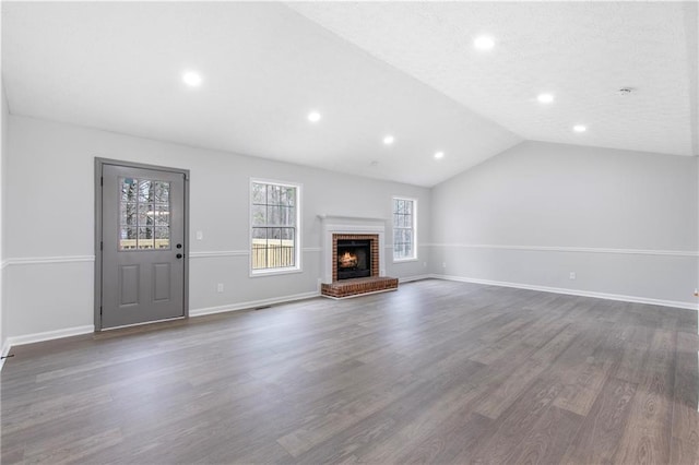 unfurnished living room with lofted ceiling, a fireplace, baseboards, and dark wood-type flooring