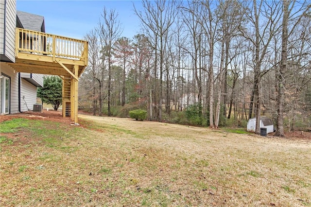 view of yard with cooling unit, stairway, and a wooden deck