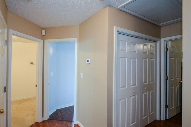 hall featuring a textured ceiling and dark hardwood / wood-style floors