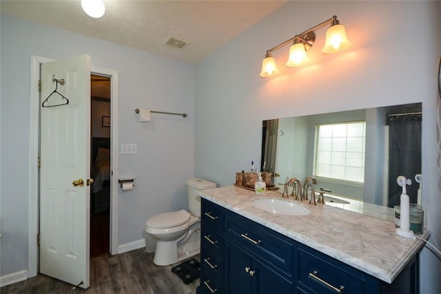 bathroom featuring toilet, vanity, and hardwood / wood-style flooring