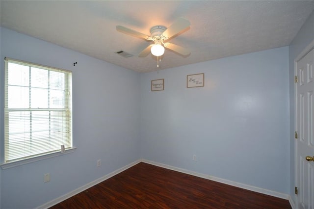 empty room with ceiling fan and dark hardwood / wood-style floors