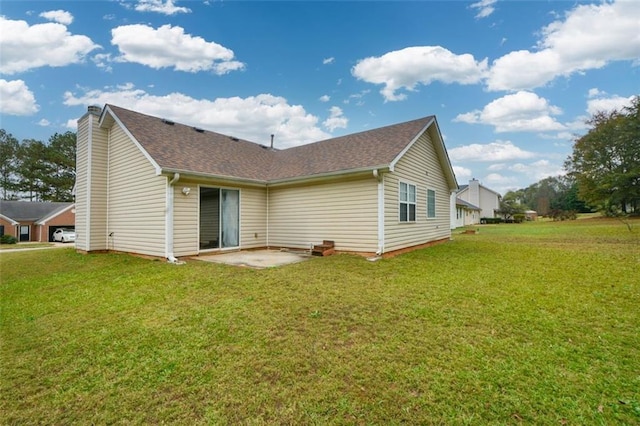 rear view of house featuring a lawn and a patio