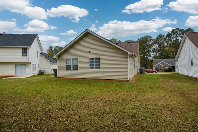 back of property with central AC unit and a yard