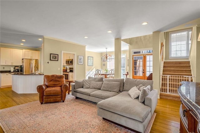 living room featuring a notable chandelier and light wood-type flooring