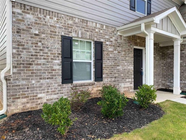 view of exterior entry featuring brick siding