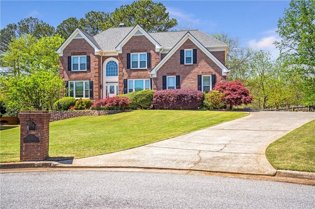 4095 Boles Creek Dr, Duluth, GA 30096 - traditional home featuring a front yard, brick siding, and driveway