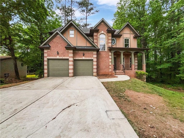 view of front of home with driveway, covered porch, brick siding, and stucco siding