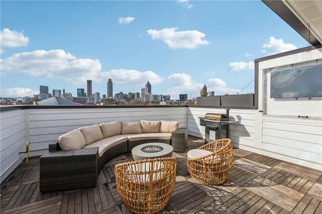 wooden terrace with an outdoor living space with a fire pit, a city view, and a grill