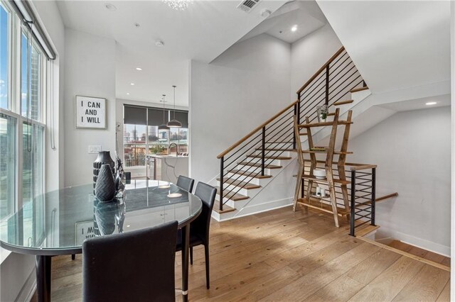 kitchen featuring white cabinetry, decorative light fixtures, a kitchen island with sink, and appliances with stainless steel finishes