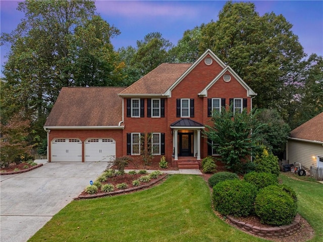 colonial house featuring a garage and a lawn