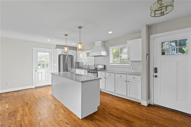 2677 Tilson Rd, Decatur, GA 30032 - kitchen with premium range hood, appliances with stainless steel finishes, white cabinets, a kitchen island, and decorative backsplash