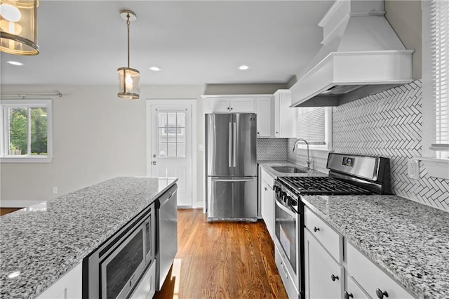 2677 Tilson Rd, Decatur, GA 30032 - kitchen featuring stainless steel appliances, a sink, custom range hood, backsplash, and light wood-style floors