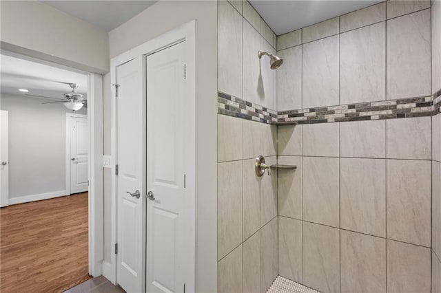 2677 Tilson Rd, Decatur, GA 30032 - bathroom featuring a tile shower, a ceiling fan, baseboards, and wood finished floors