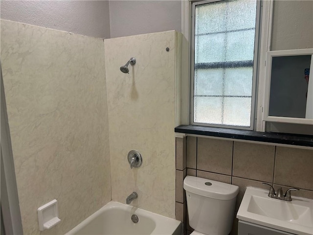full bathroom featuring a sink,  shower combination, a textured wall, and toilet