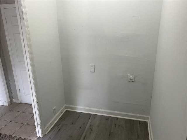 washroom with hookup for an electric dryer, baseboards, and light wood finished floors