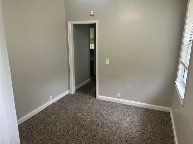 unfurnished room with carpet floors and baseboards