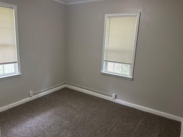 spare room with dark colored carpet and baseboards