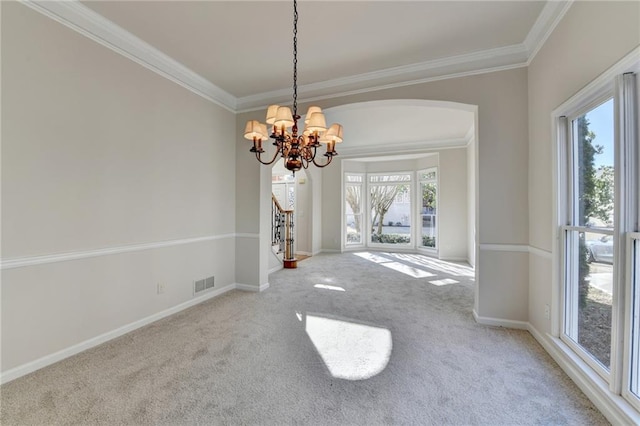 unfurnished dining area with an inviting chandelier, ornamental molding, and carpet