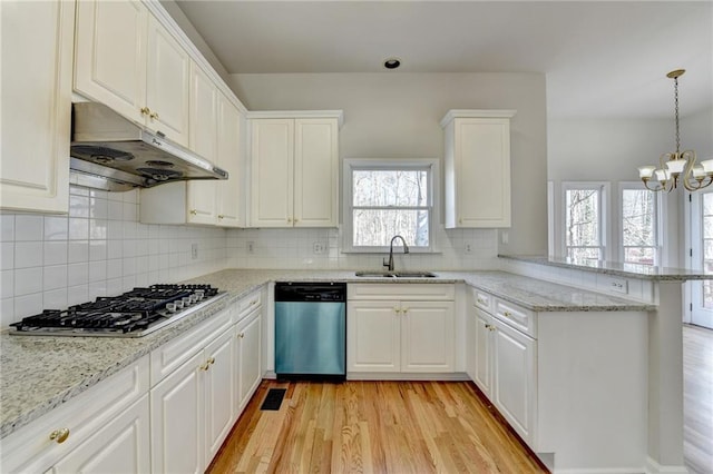 kitchen with kitchen peninsula, pendant lighting, white cabinetry, appliances with stainless steel finishes, and sink