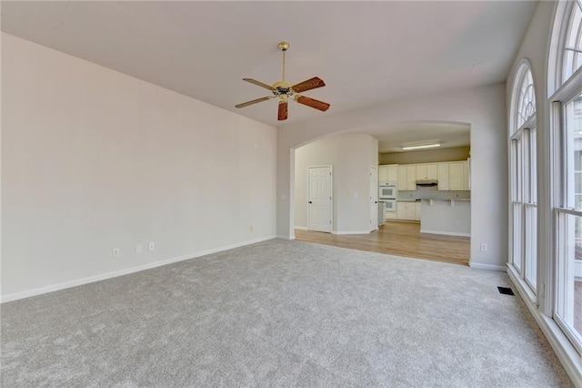 unfurnished living room with ceiling fan and light carpet