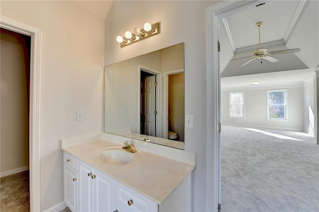 bathroom featuring toilet, crown molding, vanity, ceiling fan, and lofted ceiling