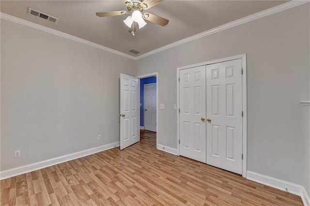 unfurnished bedroom featuring a closet, ornamental molding, ceiling fan, and light hardwood / wood-style floors