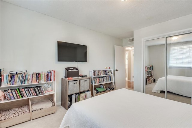 carpeted bedroom with a closet and visible vents