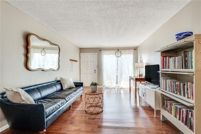 living room with a textured ceiling and wood finished floors