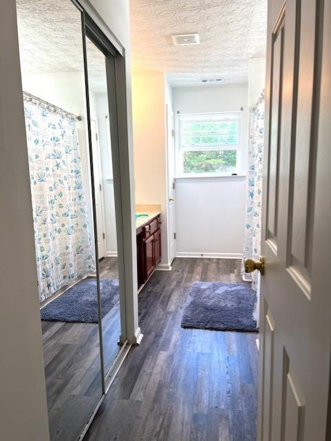 bathroom featuring vanity, hardwood / wood-style floors, a textured ceiling, and a shower with shower curtain