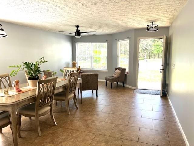 tiled dining area featuring a textured ceiling, ceiling fan, and plenty of natural light