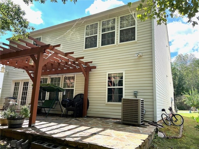 rear view of property with cooling unit, a pergola, and a patio area