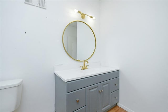 bathroom featuring visible vents, vanity, and toilet