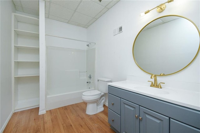 bathroom featuring toilet, a paneled ceiling, wood finished floors, bathing tub / shower combination, and visible vents