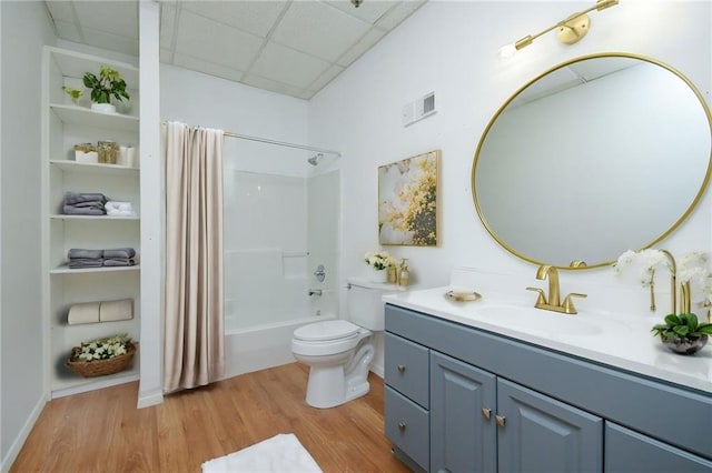 full bathroom with hardwood / wood-style flooring, toilet, vanity, and shower / tub combo with curtain