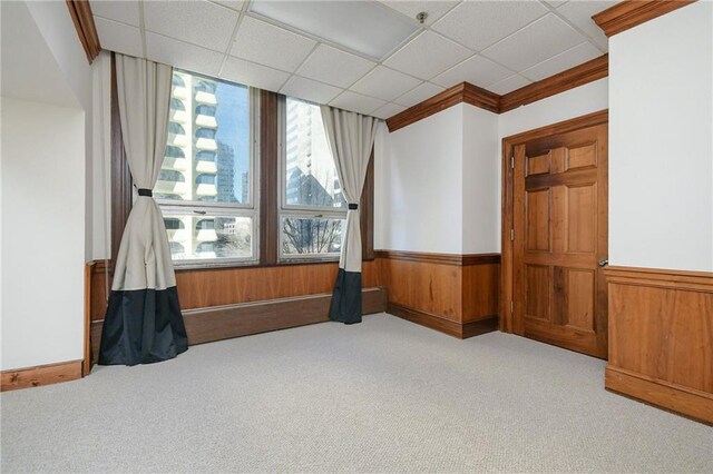 unfurnished room featuring light carpet and a paneled ceiling